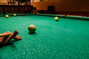 Player arm with the cue and balls on the green cloth. Russian billiard