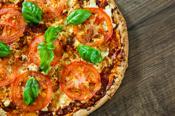Pizza with Mozzarella cheese, Tomatoes, pepper, Spices and Fresh Basil. Italian pizza. Pizza Margherita or Margarita. on wooden background. with copy space. top view