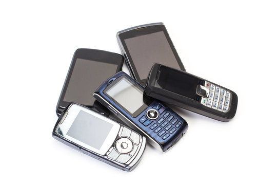 Teléfonos móviles viejos y usados sobre fondo blanco aislado. Vista superior