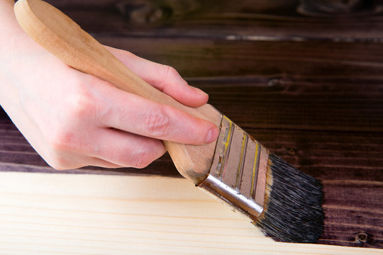 Tinting in the dark color of wood with a brush. Protection of wood from insects