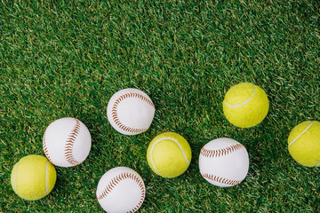 flat lay with arrangement of tennis and baseball balls on green grass
