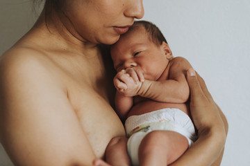 Naked mother holding her infant baby © Rawpixel.com