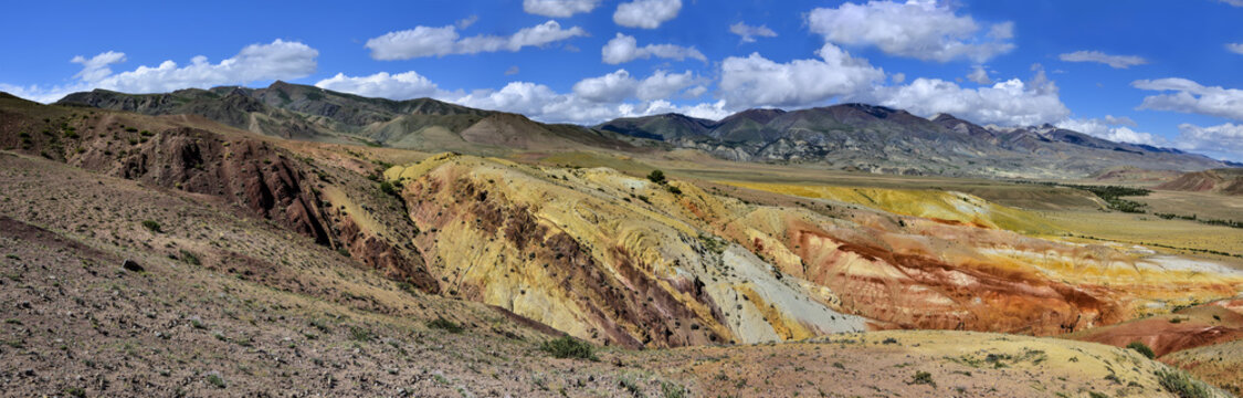 Panorama of unrealy beautiful colorful clay cliffs in Kyzyl-Chin (Kisil-Chin) valley, Altai mountains, Russia. Summer landscape, which is called Martian for its fantastic lifeless beauty