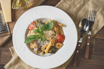 Cropped view of chef cooking Italian pasta with cheese parmesan, vegetables and egg yolk
