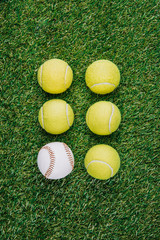 flat lay with arrangement of tennis and baseball balls on green grass