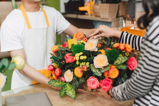 Florist giving bouquet of flower to customer in the shop