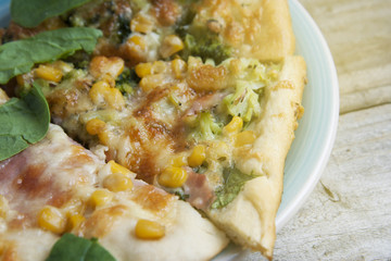 Close up slice of spinach pizza for vegetarians. Healthy nutrition vegan lifestyle. Modern italian cuisine. Wooden rustic background.