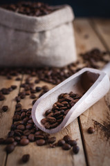 Close-up of coffee beans in a scoop on wooden background