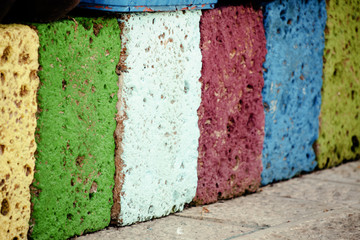 A row of bricks of different colors in a public street. Angled shot.
