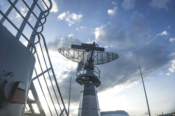 Radar on military ship against blue sky