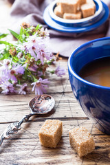 Cup of hot steaming black coffee with sugar cubes on wooden tabl