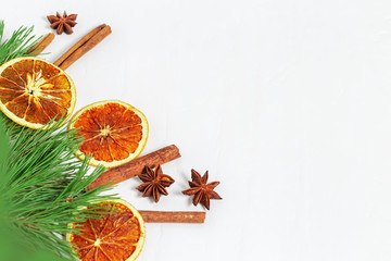 Christmas decoration. Christmas Tree with Cinnamon sticks, dried orange slices, anise stars on light concrete backdrop. Selective focus.