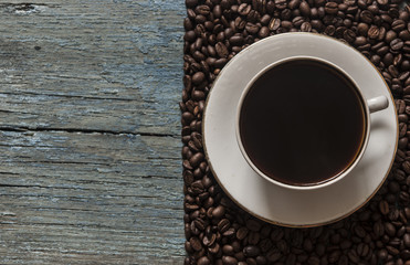 coffee cup with coffe beans on wooden table top view