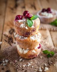 Cherry muffins with crumbly topping on wooden background 
