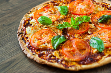 Pizza with Mozzarella cheese, Tomatoes, pepper, Spices and Fresh Basil. Italian pizza. Pizza Margherita or Margarita. on wooden background