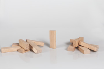 One wooden block standing and outstanding among the collapse of fall in line..