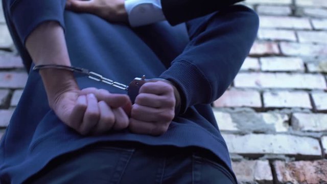 Lawyer arresting criminal, putting handcuffs on, law and order, crime punishment