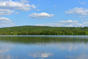 Summer landscape. Picturesque big lake with reflection of clouds in Finnish Lapland