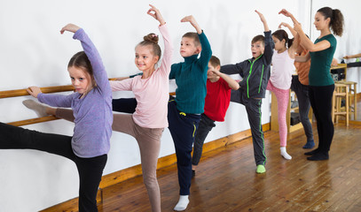 Young ballet dancers exercising in ballroom