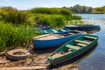 Naklejka na ściany i meble The rural fisher boats moored on the shore among thickets of bulrush. Don river, Russia