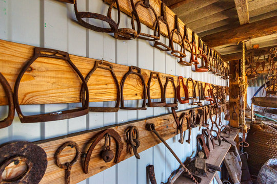 The set of old rusty steel stirrups hanging on the wall