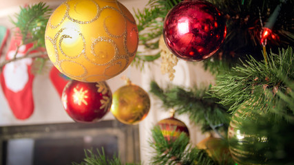 Fototapeta na wymiar Beautiful background for winter holidays. Colorful baubles hanging on Christmas tree branches