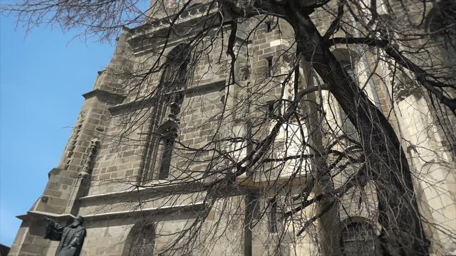 Footage of gothic architecture, The Black Church in Brasov, Romania, Johannes Honterus statue, tilt