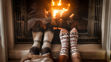 Closeup image of feet in woolen socks lying by the fireplace