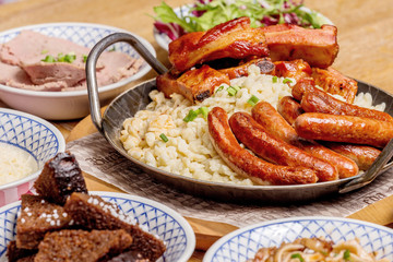 Oktoberfest food menu: sausages, fried bacon, pork ears, salad.