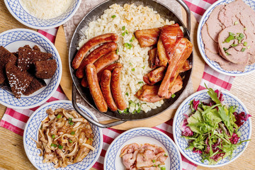 Oktoberfest food menu: sausages, fried bacon, pork ears, salad.