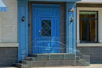 blue wooden door and threshold on the wall of a building with a window