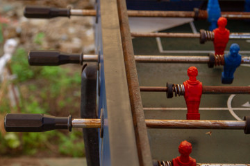 Old rusty table for playing table football. Figures of football players in table football. Selective focus.