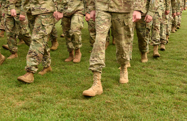 Soldiers marching on green grass. US Army