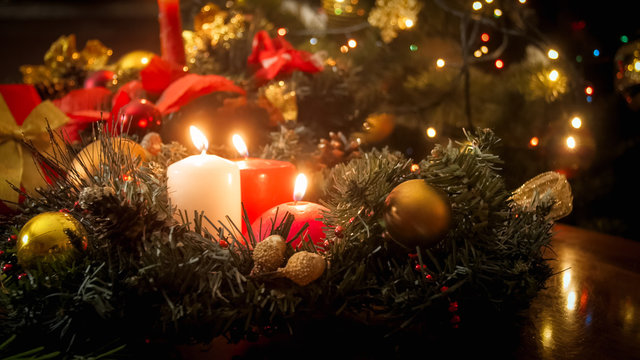 Toned image of burning candles and Christmas wreath on winter holidays