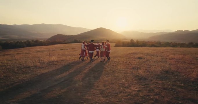 Aerial view: A team of dancers circling in dance in the glade