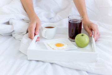 Obraz na płótnie Canvas Young beautiful woman having breakfast in bed