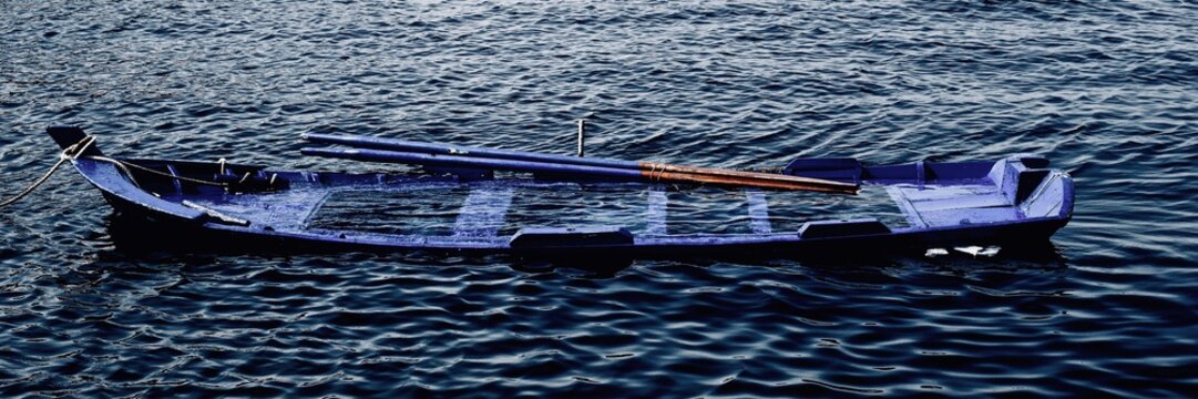 una barca con remos hundi&eacute;ndose