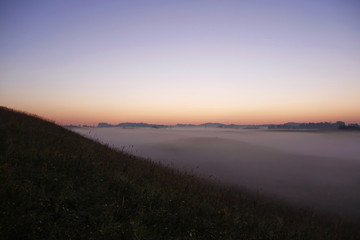 Fototapeta na wymiar Colorful sunrise over rolling hills in the fog