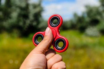 Red fidget spinner in female hand