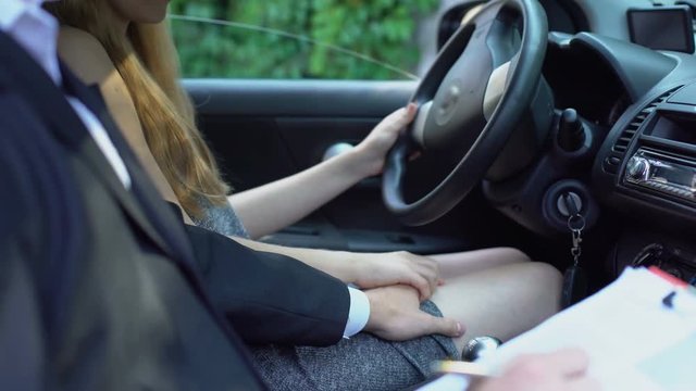 Young woman refusing instructor flirt during driving lesson, teacher harassment