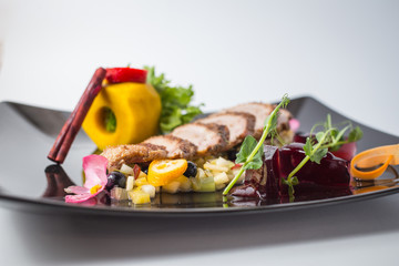 Fresh salad from duck fille with fruits, jellies, green and cinnamon