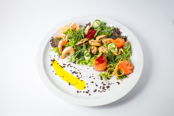 Seafood fresh salad with shrimps, mussels, salmon, green and cucumber