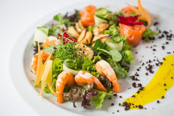 Seafood fresh salad with shrimps, mussels, salmon, green and cucumber