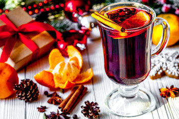 Christmas mulled wine with spices in cup on wooden background