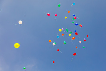 Multicolored balloons flying at sky