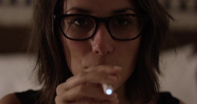 Young 20s woman taking hit off e-cigarette