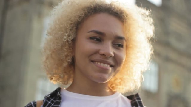 Positive, mixed-race blonde adolescent smiling flirty standing, sunshine, campus