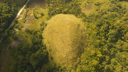 Amazingly shaped Chocolate hills on sunny day on Bohol island, Philippines. Aerial view Chocolate Hills in Bohol, Philippines are earth mounds scattered all over the town of Carmen. Travel concept.
