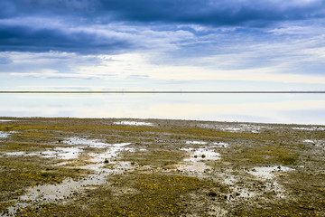 Beautiful isolated green colored Iceland lake with blue skies and puffy clouds. Reflection on water.