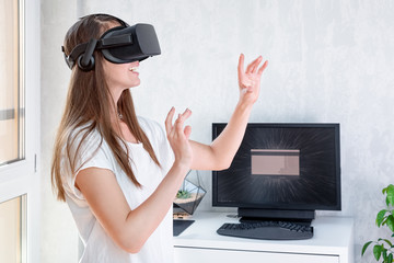 Smiling positive woman wearing virtual reality goggles headset, vr box. Connection, technology, new generation, progress concept. Girl trying to touch objects in virtual reality